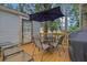 Inviting outdoor deck with table, chairs, and grill, perfect for relaxing and entertaining guests at 1377 Tucker Woods Dr, Norcross, GA 30093