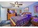 Primary bedroom featuring blue walls, ceiling fan, plaid comforter, and wood furniture at 1377 Tucker Woods Dr, Norcross, GA 30093