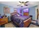Primary bedroom showcasing blue walls, ceiling fan, plaid comforter, and natural-wood furniture at 1377 Tucker Woods Dr, Norcross, GA 30093