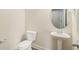 Elegant half bathroom featuring a pedestal sink, oval mirror, and toilet at 255 Orchard Dr, Covington, GA 30014