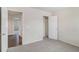 Carpeted bedroom with a doorway to an adjacent room and a closet with a door at 255 Orchard Dr, Covington, GA 30014