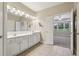 Bright bathroom featuring double sinks and opens to the main bedroom with backyard views at 2721 Grapevine Cir # 1701, Cumming, GA 30041