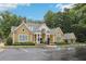 Exterior of a yellow-sided community building with well-manicured landscaping and ample parking spaces at 2721 Grapevine Cir # 1701, Cumming, GA 30041