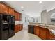 Kitchen shows stone countertops, tile backsplash, black appliances, and view to dining area at 2721 Grapevine Cir # 1701, Cumming, GA 30041