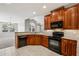 Well-lit kitchen featuring wood cabinetry, granite countertops, and modern appliances at 2721 Grapevine Cir # 1701, Cumming, GA 30041