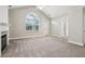 Bright living room with vaulted ceiling, fireplace, carpet flooring, and a large window at 2721 Grapevine Cir # 1701, Cumming, GA 30041