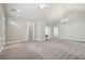 Bright, open living room with neutral walls, gray carpeting, and modern chandelier at 2721 Grapevine Cir # 1701, Cumming, GA 30041