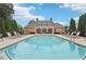 Community pool featuring lounge chairs and a pristine swimming pool with a yellow pool house at 2721 Grapevine Cir # 1701, Cumming, GA 30041