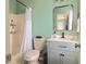 Charming bathroom featuring a shower-tub combo, blue vanity with a white sink, and a stylish mirror at 4336 Thorngate Ln, Acworth, GA 30101