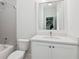 Bathroom featuring a white vanity with solid surface countertop, toilet, and subway tiled tub and shower combo at 5971 Brundage Lane, Norcross, GA 30071