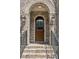 Close-up of arched wood front door with brick surround and decorative lantern sconces at 5971 Brundage Lane, Norcross, GA 30071