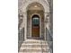 Close-up of a beautiful arched wood front door, brick steps, and iron railings at 5971 Brundage Lane, Norcross, GA 30071