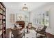 Cozy living room featuring hardwood floors, a piano, and custom bookshelves at 5971 Brundage Lane, Norcross, GA 30071