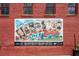Colorful 'Greetings from Norcross' mural on a brick wall adds local charm at 5971 Brundage Lane, Norcross, GA 30071
