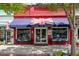 Taste of Britain storefront featuring a British flag awning, outdoor seating, and a charming red-brick facade at 5971 Brundage Lane, Norcross, GA 30071