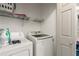 Functional laundry room with a washer, dryer and storage shelving at 1523 Dillard Rd, Stone Mountain, GA 30088