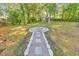 Landscaped backyard featuring a stone walkway leading to a charming fire pit surrounded by lush grass at 2254 Glendale Dr, Decatur, GA 30032