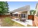 Backyard with a table, chairs, and grass lawn, patio against the house, and wooden fence at 320 Roland Manor Dr, Dacula, GA 30019
