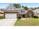 Charming brick home with well-manicured lawn and two-car garage at 320 Roland Manor Dr, Dacula, GA 30019