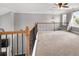 Cozy loft area with decorative railing, ceiling fan, and bright windows at 320 Roland Manor Dr, Dacula, GA 30019