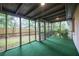 A screened porch featuring green carpeting, offering a tranquil outdoor space with views of the backyard at 5384 Blackhawk Dr, Acworth, GA 30102
