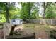 The backyard includes a wooden fence, mature trees, a storage shed, and an area for outdoor activities at 3261 N Fulton Ave, Atlanta, GA 30354