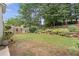 A spacious backyard featuring healthy green grass, a wooden fence, and various potted plants at 3765 Peachbluff Ct, Duluth, GA 30097