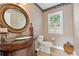 Stylish powder room with dark wood vanity, decorative mirror, and patterned wallpaper at 3765 Peachbluff Ct, Duluth, GA 30097