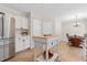 Well-lit kitchen leading to dining area, featuring stainless steel refrigerator and center island at 3765 Peachbluff Ct, Duluth, GA 30097