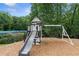 A wooden playset and playground sit amongst trees in the backyard at 3765 Peachbluff Ct, Duluth, GA 30097