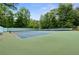 A community tennis court surrounded by lush greenery and trees at 3765 Peachbluff Ct, Duluth, GA 30097