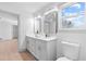 Modern bathroom with double vanity, bright mirrors, and a toilet, adjacent to a hallway at 42 Riverdale St, Canton, GA 30114
