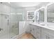 Modern bathroom with glass shower, double vanity, and ample natural light from the window at 42 Riverdale St, Canton, GA 30114