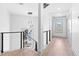 Bright hallway with modern railing, light hardwood floors and pendant lighting leading to the staircase at 42 Riverdale St, Canton, GA 30114