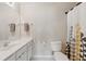 Neutral bathroom features a single sink vanity, a toilet, and a shower/tub with a decorative curtain at 771 Tulip Poplar Way, Lawrenceville, GA 30044