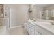 Bathroom with double sink vanity, modern fixtures, walk-in shower with glass door, and neutral tile floors at 771 Tulip Poplar Way, Lawrenceville, GA 30044