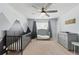 Neutral Bedroom showcasing a crib, changing table, dresser, and mountain mural with modern ceiling fan at 771 Tulip Poplar Way, Lawrenceville, GA 30044