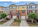 Charming townhome exterior with manicured landscaping, inviting entrances, and attached garages at 771 Tulip Poplar Way, Lawrenceville, GA 30044
