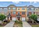 Attractive townhome with brick facade, colorful siding, driveway, one-car garage, and manicured landscaping at 771 Tulip Poplar Way, Lawrenceville, GA 30044