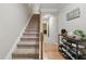 Hallway with carpeted stairs, wooden railing, shoe rack, and hardwood flooring visible in the hall at 771 Tulip Poplar Way, Lawrenceville, GA 30044