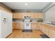Bright kitchen features wood floors, countertops, tile backsplash, white appliances, and natural wood cabinets at 771 Tulip Poplar Way, Lawrenceville, GA 30044