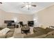 Casual living room area with comfortable sofas, ceiling fan, and entertainment center at 771 Tulip Poplar Way, Lawrenceville, GA 30044