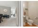 Neutral powder room with toilet and sink adjacent to the dining room and stairway at 771 Tulip Poplar Way, Lawrenceville, GA 30044