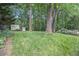 Expansive backyard with lush green grass, mature trees, a storage shed, and patio seating area at 1747 Remington Rd, Atlanta, GA 30341
