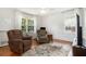 Cozy bedroom with hardwood floors, lots of light, a ceiling fan, and two comfortable arm chairs at 1747 Remington Rd, Atlanta, GA 30341