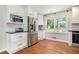 Bright kitchen with white cabinets, stainless steel refrigerator, and a view to the backyard at 1747 Remington Rd, Atlanta, GA 30341