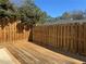 Wooden deck with a privacy fence, green bushes, and houses in the background at 731 Hanover Se Ln, Marietta, GA 30067