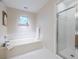 Bathroom showcasing a soaking tub and a glass-enclosed shower, designed with a clean, neutral palette at 1001 Dancing Fox Rd, Decatur, GA 30032