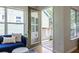 Bright living area featuring a blue sofa, plush ottomans, a door to the deck, and ample natural light at 1001 Dancing Fox Rd, Decatur, GA 30032