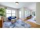 Bright living area featuring a blue sofa, plush ottomans, a patterned rug, and ample natural light at 1001 Dancing Fox Rd, Decatur, GA 30032